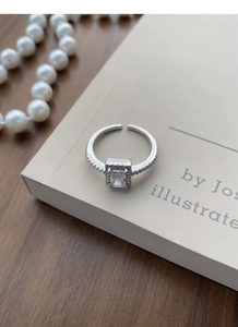 Detail of S925 sterling silver ring with square zircon stone on a vintage book