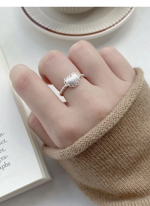 Macro view of S925 sterling silver frosted heart ring with lace edge on model hand
