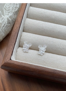 Macro detail of S925 sterling silver butterfly stud earrings with delicate hollow filigree