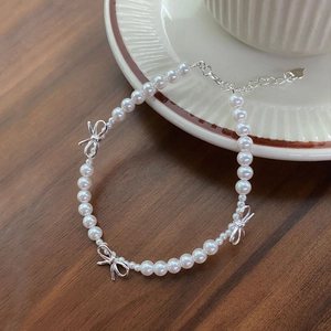 Bracelet de perles en argent S925 avec breloques noeuds sur une soucoupe en céramique