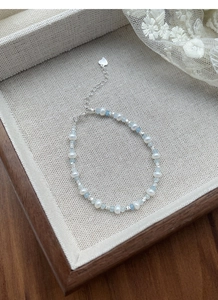 Detailed view of S925 sterling silver heart tag and freshwater pearl beaded bracelet