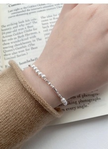 Close-up of S925 silver pearl bracelet with delicate beads worn on a female wrist
