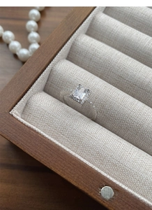 Macro shot of a rectangular zircon ring on velvet inside a premium wooden jewelry box
