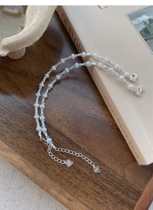 Close-up of S925 sterling silver heart charm on freshwater pearl and aquamarine bracelet