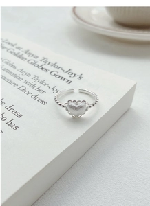 Detailed macro of S925 silver heart ring with frosted finish on vintage book pages