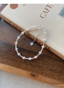 Macro shot of S925 silver heart charm and extension chain on pearl bead bracelet