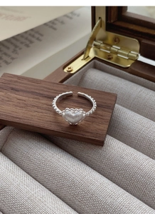 Detailed macro of S925 sterling silver frosted heart ring with vintage beaded open band