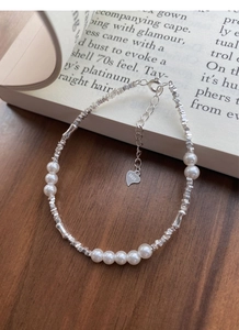 Macro shot of S925 sterling silver pearl bracelet with lobster clasp on a vintage book