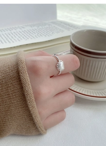 Detailed view of frosted silver heart ring with beaded band worn in a lifestyle setting