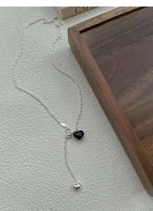 Close-up of S925 silver necklace with black heart pendant and hanging tassel detail