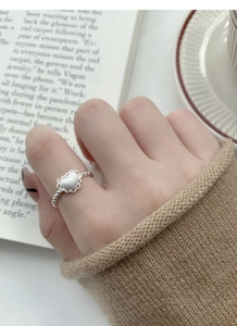 Close-up of S925 sterling silver heart ring with matte finish and beaded band detail