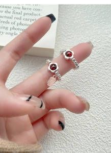 Macro detail of S925 silver beaded rings with garnet flower and Fu character charm
