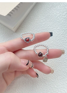 Detail of S925 sterling silver beaded rings with garnet flower and Fu pendant