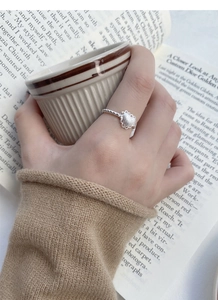 Macro detail of silver heart ring with frosted texture and twisted rope band design