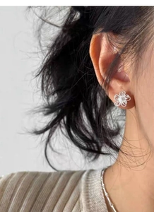 Vue détaillée d'une boucle d'oreille fleur en argent S925 avec un zircon central brillant