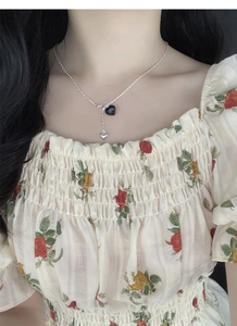 Close-up of S925 silver double heart pendant necklace with black tassel detail on model