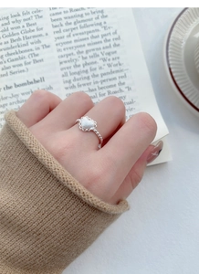 Detail of S925 sterling silver heart ring with lace edges and beaded band on hand