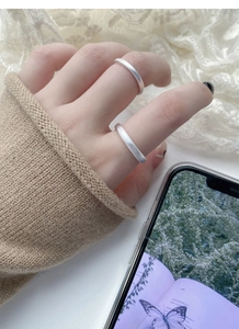 Gros plan détaillé des bagues de couple en argent sterling S999 avec finition mate sablée