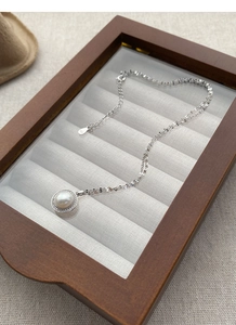 Gros plan du poinçon S925 sur le collier avec un pendentif en perle d'eau douce ronde