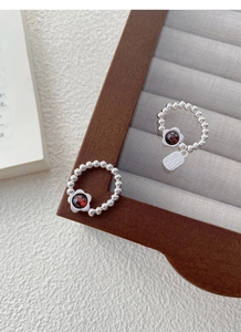 Detailed macro view of S925 silver beaded garnet flower ring with Fu character tag