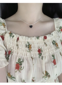 Close-up of S925 sterling silver necklace with a black heart pendant on female neck