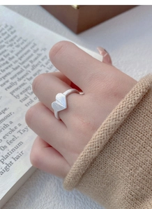 Detail of S925 silver heart ring with brushed matte texture on model's hand