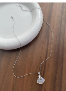 Gros plan détaillé du poinçon S925 et du pendentif en calcédoine blanche sur collier