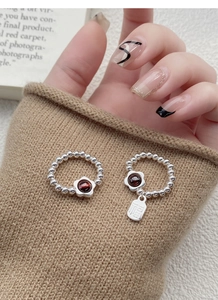 Close-up of S925 silver beaded flower ring with garnet and Fu character pendant