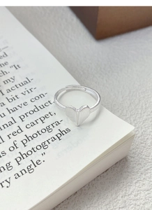 Macro shot of silver heart ring with brushed matte texture on open book page