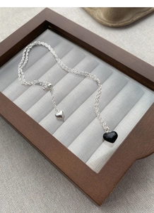 Macro shot of silver S925 heart necklace with black pendant and adjustable slider bead