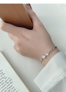 Detail of S925 silver bamboo link bracelet with white shell and sparkling zircons