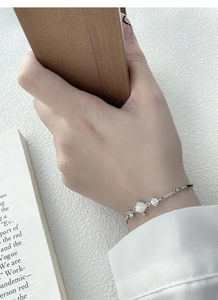 Detail of S925 silver bamboo bracelet with white shell flower and cubic zirconia