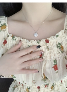 Gros plan du collier en argent S925 avec perle ronde et pendentif en zircon sur cou