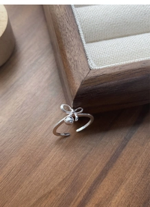 Close-up of S925 sterling silver bow ring with polished bead and adjustable open band