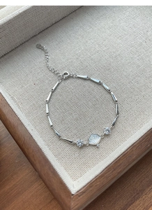Detailed macro view of S925 silver bamboo bracelet with white mother of pearl shell pendant