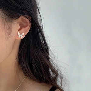 Elegant white butterfly S925 silver stud earrings on female model with minimalist style