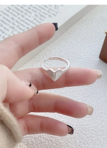 Macro detail of S925 sterling silver origami heart ring with matte brushed finish