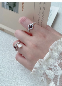 Detailed view of S925 silver beaded rings with garnet flower and Fu character charm