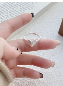 Macro shot of S925 sterling silver heart ring with brushed metal texture and origami design