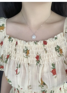 Gros plan du collier en argent S925 avec perle d'eau douce ronde et pavé de diamants