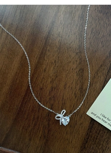 Detailed view of S925 sterling silver bow heart pendant with sparkling pavé cubic zirconia