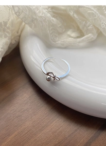 Close-up of S925 sterling silver bow ring with bead charm and engraved hallmark