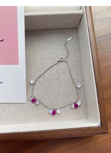 Détail d'un bracelet en argent S925 avec des charmes en zircon rose magenta
