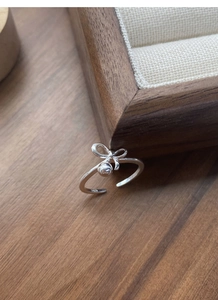 Macro shot of S925 sterling silver ring showing ribbon bow, silver bead and S925 hallmark