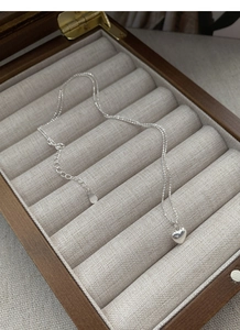 Close-up of S925 silver heart necklace on jewelry box with adjustable 925 stamp detail