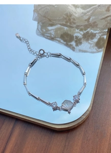 Detailed macro view of S925 silver bamboo chain with white shell pendant and crystals