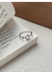 Macro shot of S925 sterling silver open ring with dual heart design and sparkling zircon
