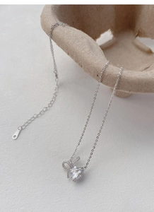 Macro shot of S925 sterling silver heart necklace with bowknot detail and zircon stone