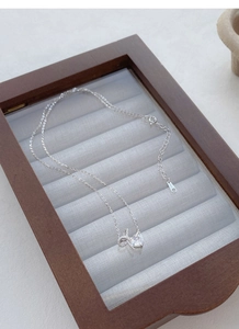 Close-up of S925 sterling silver necklace with bow and heart diamond pendant in a box