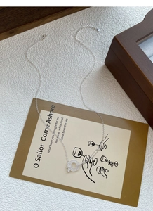 Détail du collier tulipe en argent S925 avec pendentif donut blanc et petite clé